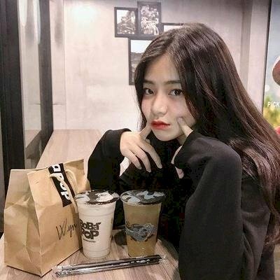 Tạo dáng ngồi nghiêng nhìn hướng về máy ảnh, hai tay chống trỏ trên bàn và đưa lên làm duyên trên má