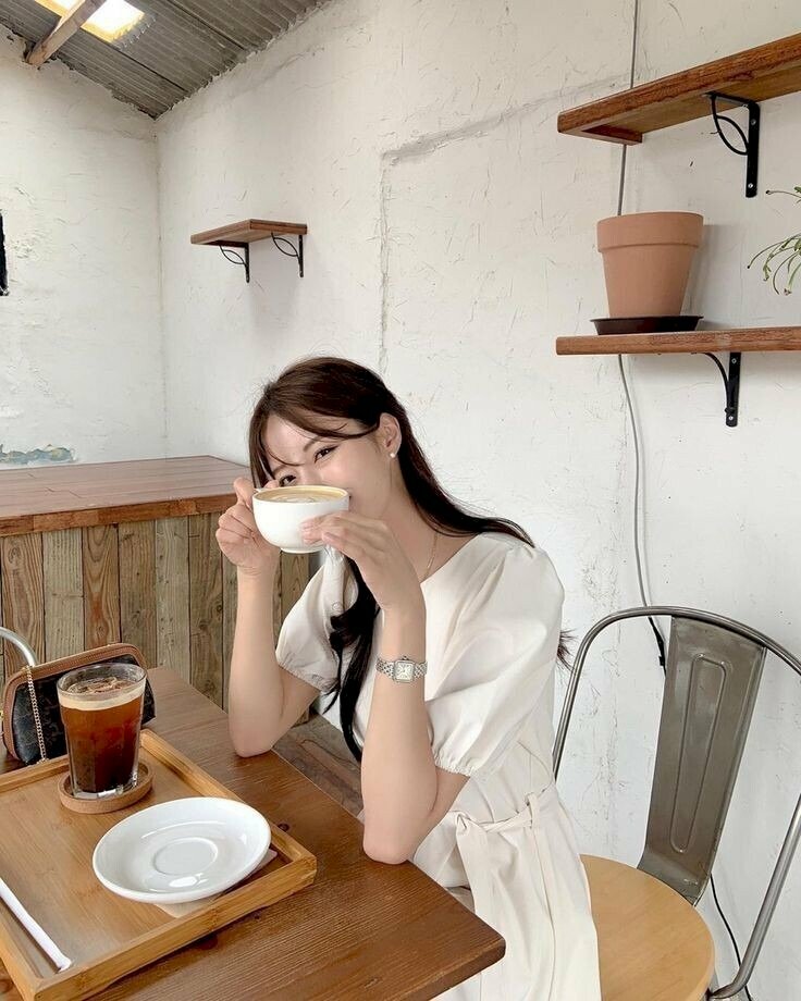 Tạo dáng ngồi trên ghế thật tự nhiên, đầu khẽ nghiêng với mắt như biết cười nhìn về máy ảnh, hay tay chống trỏ lên bàn cầm cốc trà sữa che nửa khuôn mặt