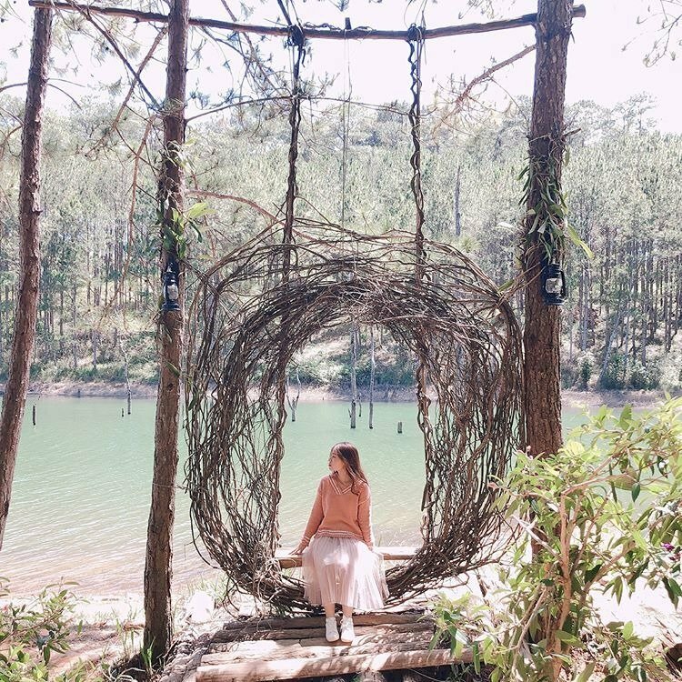 Tạo dáng cô gái ngồi trên xích đu thật tự nhiên, mặt quay nghiêng hướng nhìn về một phía