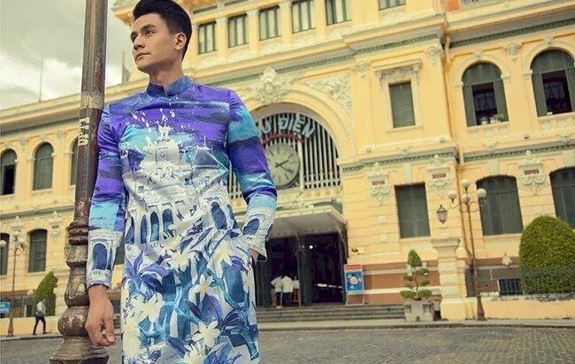 Tạo dáng đứng dựa vai, một tay đút túi quần cùng góc chụp từ dưới lên