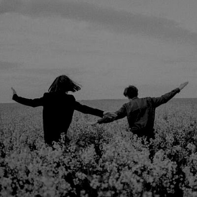 Ảnh cặp đôi đen trắng đang vui đùa, chạy trên cánh đồng hoa