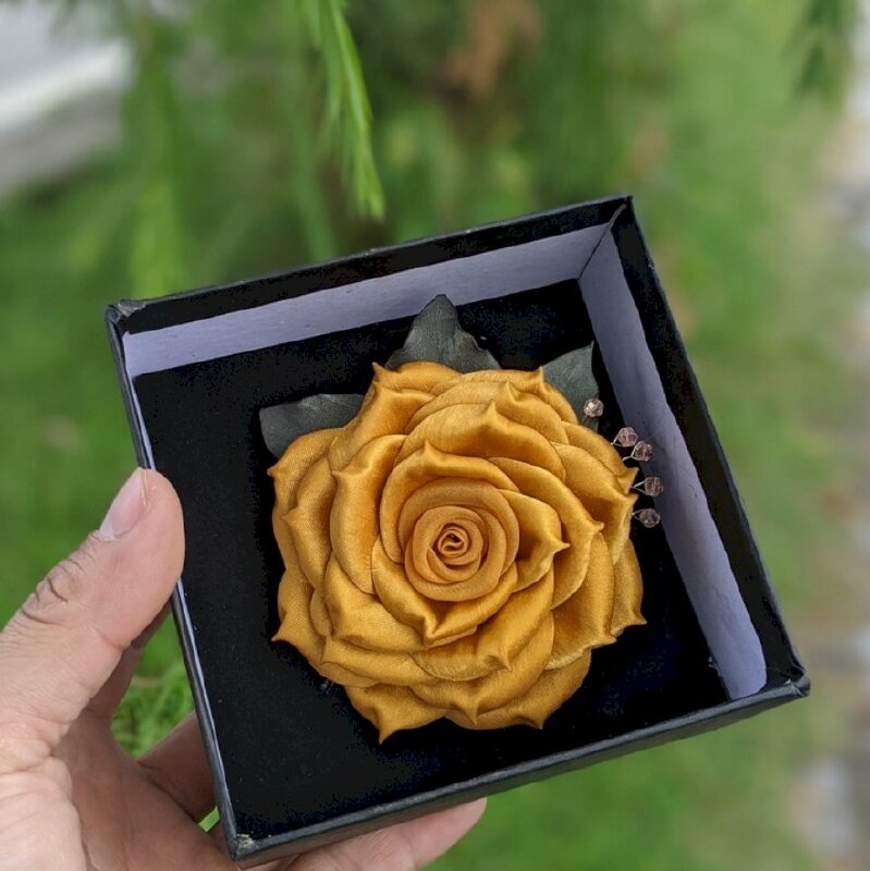 Hình ảnh hoa hồng vàng rực rỡ cài trên ngực áo đầy quý tộc và thẩm mỹ cao