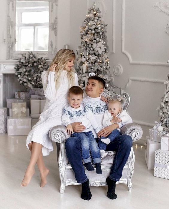 Tạo dáng chụp ảnh cùng cây thông Noel trong nhà, với tay bố ẳm 2 bé, mắt nhìn vợ cười ngọt ngào