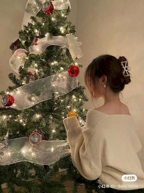 Tạo dáng chụp hình với cây thông Noel với góc chụp từ sau lưng cô gái trong bộ áo trắng trễ vai rất dễ thương