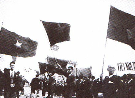 Hình ảnh kiều bào giương cao cờ, biểu ngữ chào đón Chủ tịch Hồ Chí Minh và phái đoàn Chính phủ Việt Nam DCCH (22-6-1946)