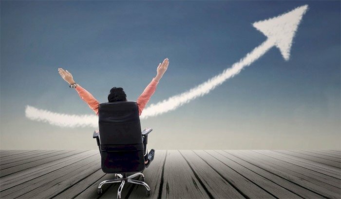 Hình ảnh thành công trong kinh doanh với đôi tay dang rộng tự tin và mũi tên tăng trưởng đi lên