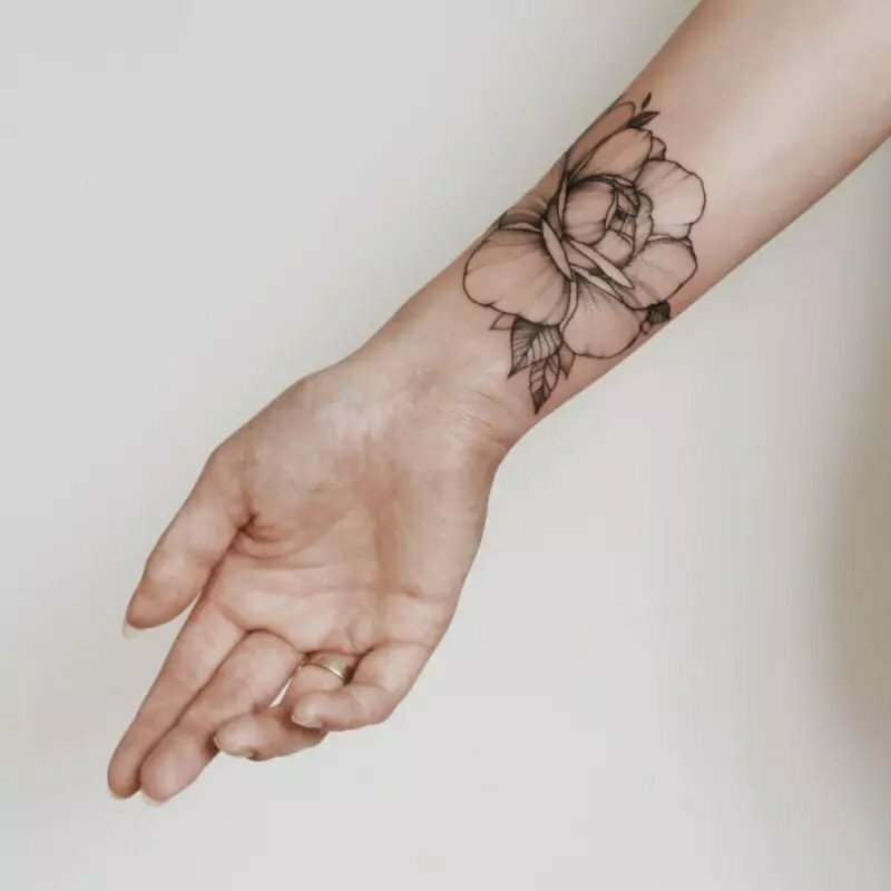 Tattoo trắng đen một bông hoa mẫu đơn nở rộ đẹp nhẹ nhàng trên cổ tay dành cho các bạn gái