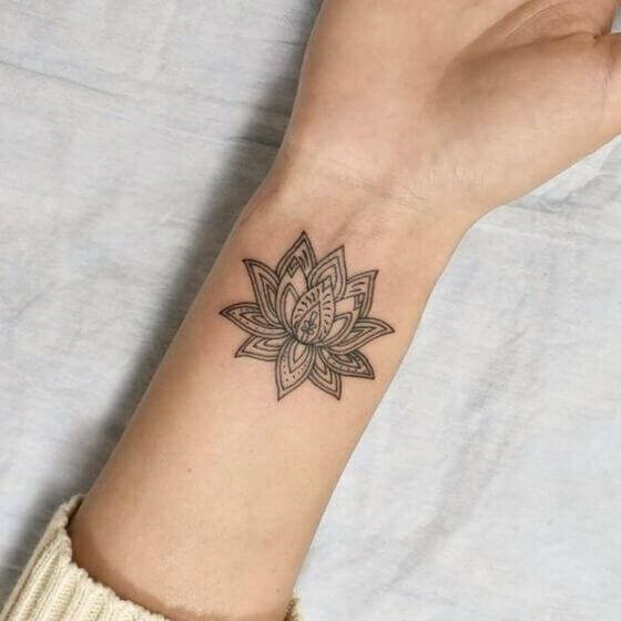 Tattoo White đen sạm hoa sen với hình họa thẩm mỹ và nghệ thuật ở cổ tay