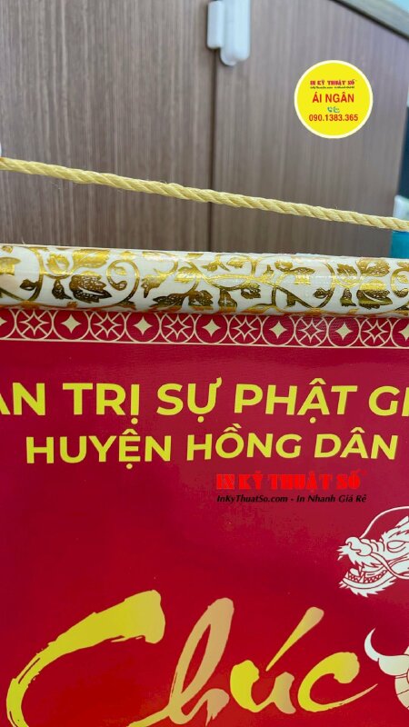 In liễn chúc Tết được nẹp gỗ hoa văn 2 đầu gắn dây treo tường trang trí