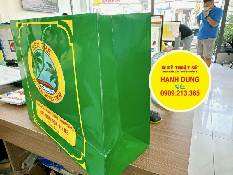 In túi giấy quà tặng chất liệu giấy Ivory, cán màng bóng, quai dù xanh lá cây tương tự màu túi