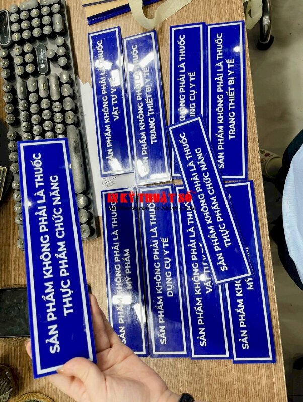 In bảng tên kệ tủ nhà thuốc Sản phẩm không phải là... , in UV thuận Mica xanh 5li cắt hình chữ nhật - INKTS3345